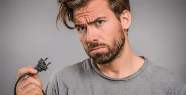Frustrated man holding an unplugged power cable